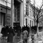 На фото снят вариант фасада у кинотетра Октябрь в Красноярске, который менялся несколько раз за 100 лет. Так же в кадре хорошо видны жители того времени.